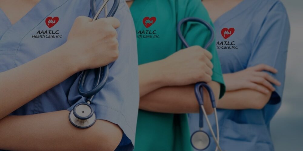 Three healthcare workers in scrubs with stethoscopes across their chests, displaying a heart logo on their uniforms.